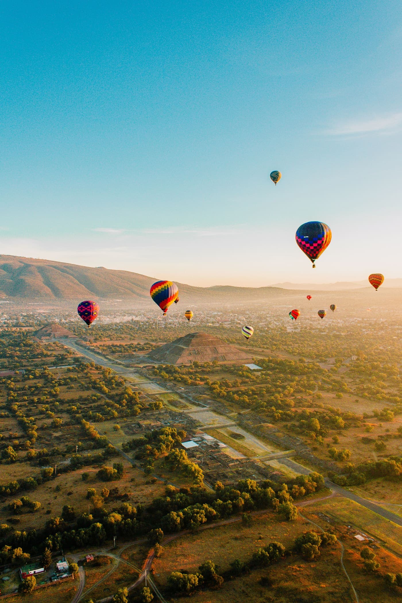 Hot-air balloons drifting over warm open fields