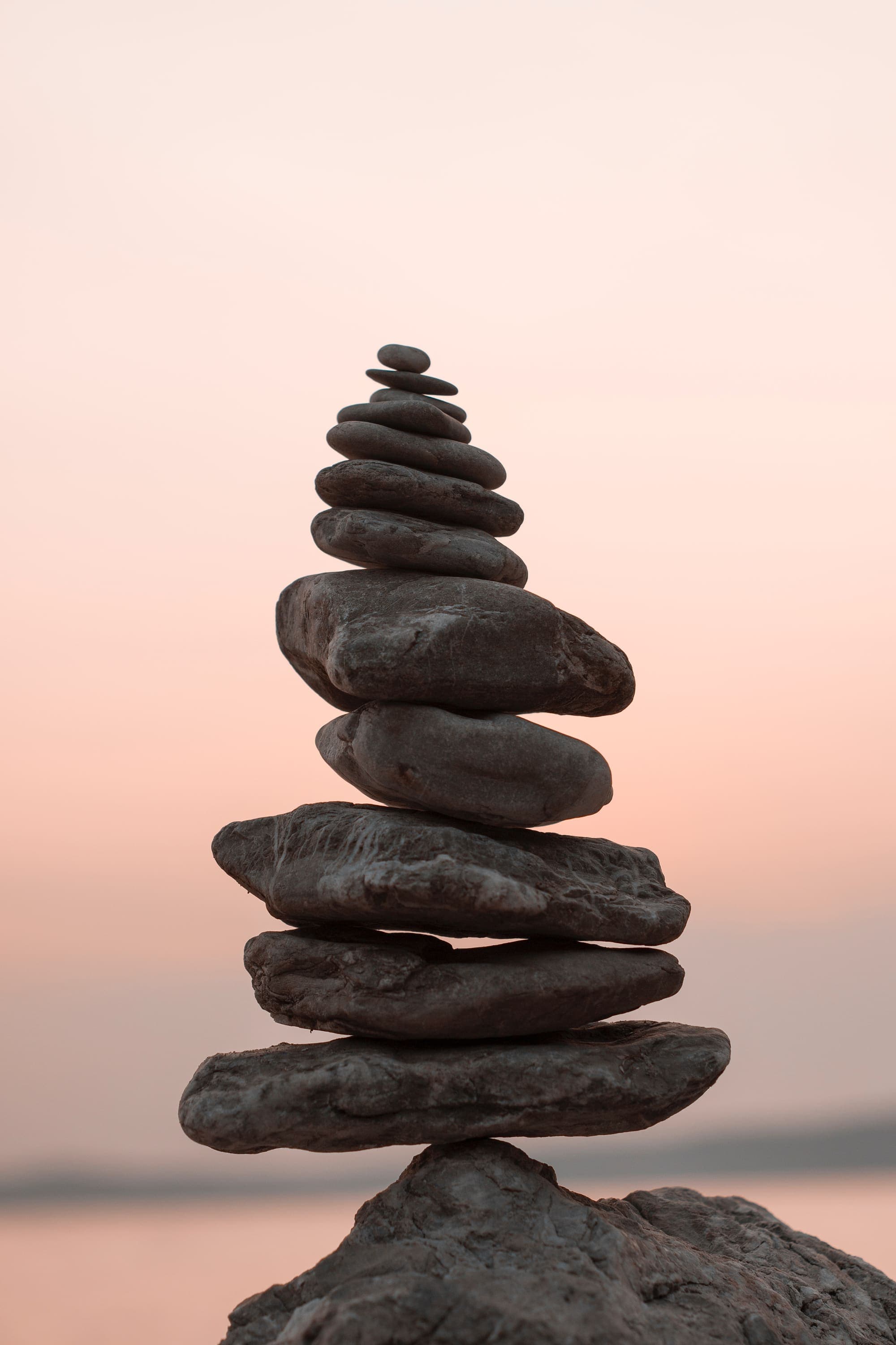 A stone cairn stacked against a soft evening sky