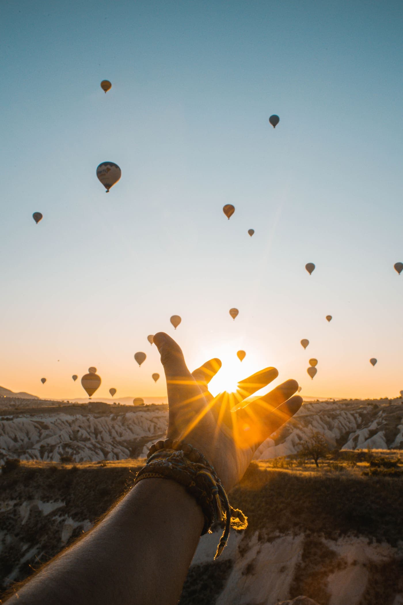 Balloons rising into a sunset sky