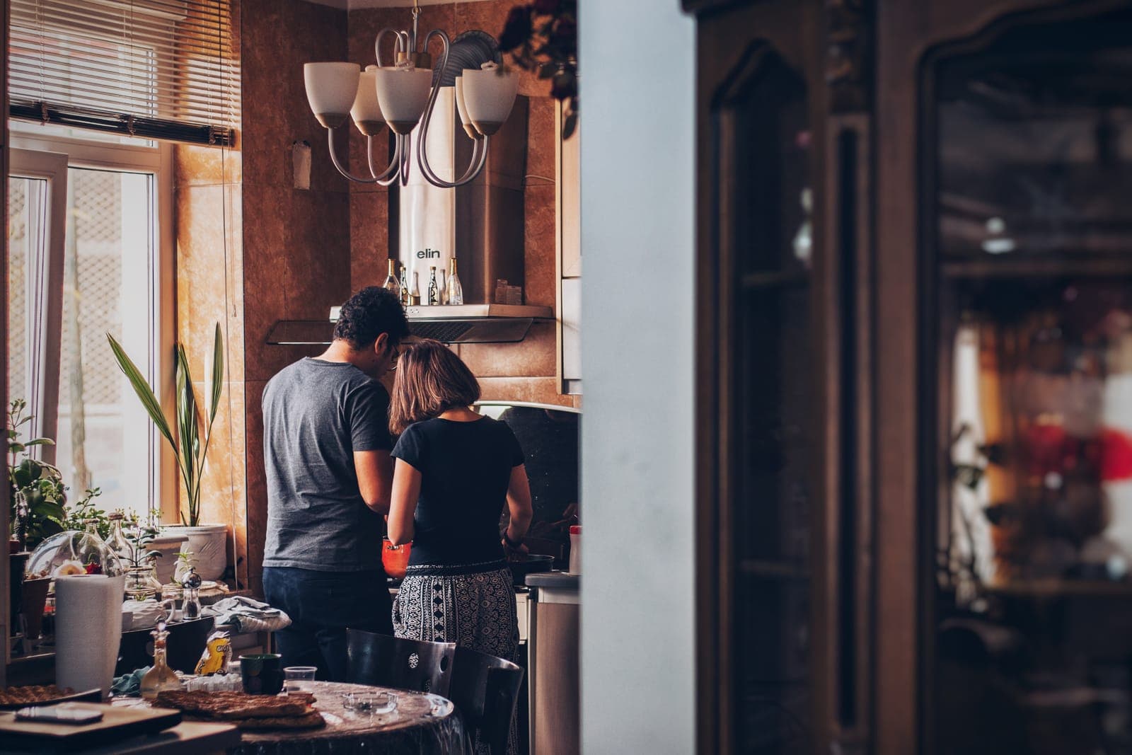 Two family members talking together in a warm, sunlit kitchen